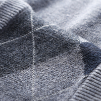 Grauer Wollpullover mit Argyle-Muster, weiches Material, Nahaufnahme, Herrenmode.