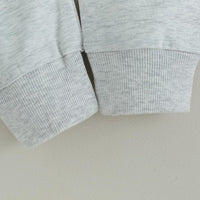 Grauer Baumwollpullover, gerippte Bündchen, weiches Material, lässige Mode, Herrenbekleidung.