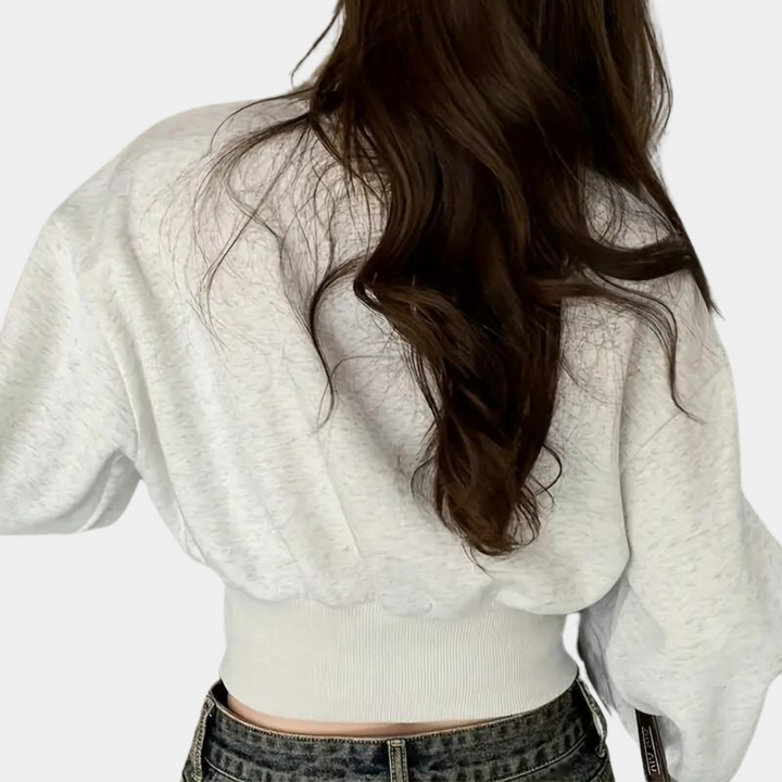 Frau in weißem Pullover mit langen Ärmeln und braunem Haar, Rückansicht, modisch, lässig.