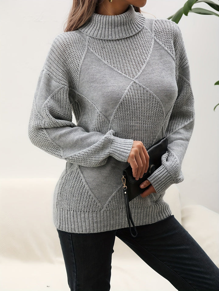 Frau in grauem Strickpullover mit Rollkragen, hält schwarze Clutch, modisch, elegant.