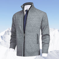Grauer Herren-Strickjacke mit Reißverschluss, eleganter Stil, vor schneebedeckten Bergen.