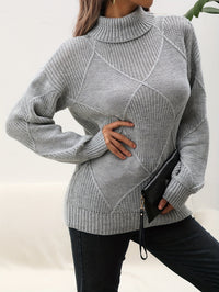 Frau in grauem Strickpullover mit Rollkragen, hält schwarze Clutch, modisch, elegant.