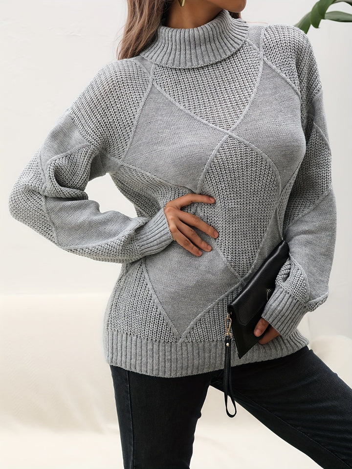 Frau in grauem Strickpullover mit Rollkragen, hält schwarze Clutch, modisch, elegant.