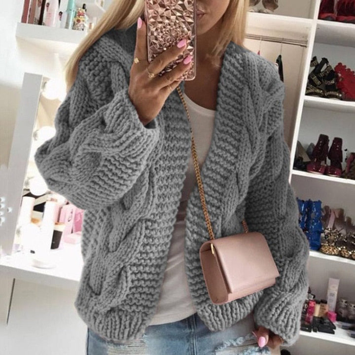 Frau in grauem Strickpullover, rosa Handtasche, Spiegel-Selfie, modische Kleidung, gemütlich.