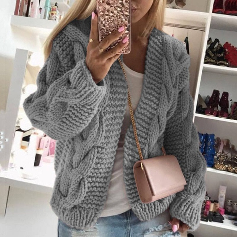 Frau in grauem Strickpullover, rosa Handtasche, Spiegel-Selfie, modische Kleidung, gemütlich.