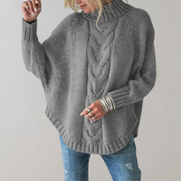 Frau in grauem Strickpullover mit Zopfmuster und Rollkragen, lässige Mode, Herbstkleidung.