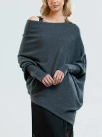 Frau in grauem Oversize-Pullover aus Kaschmir, schulterfrei, modisch, elegant, Herbstmode.