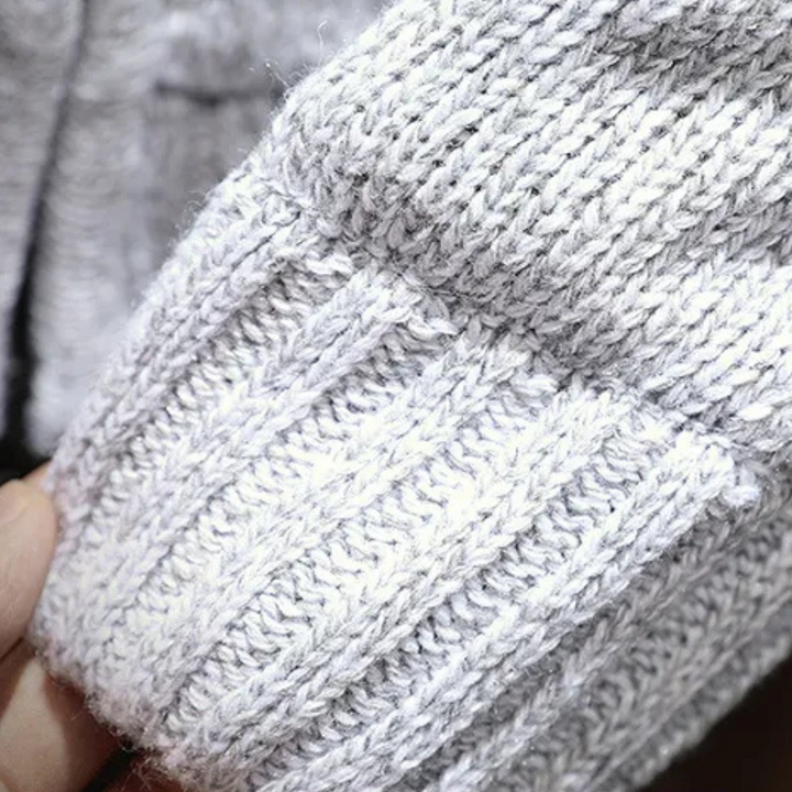 Grauer Strickpullover aus Wolle, Nahaufnahme, weiches Material, modisches Winterkleidungsstück.