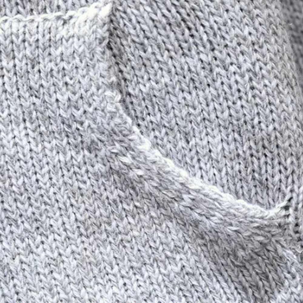 Grauer Strickpullover aus Wolle, Nahaufnahme, weiches Material, modisch, gemütlich.