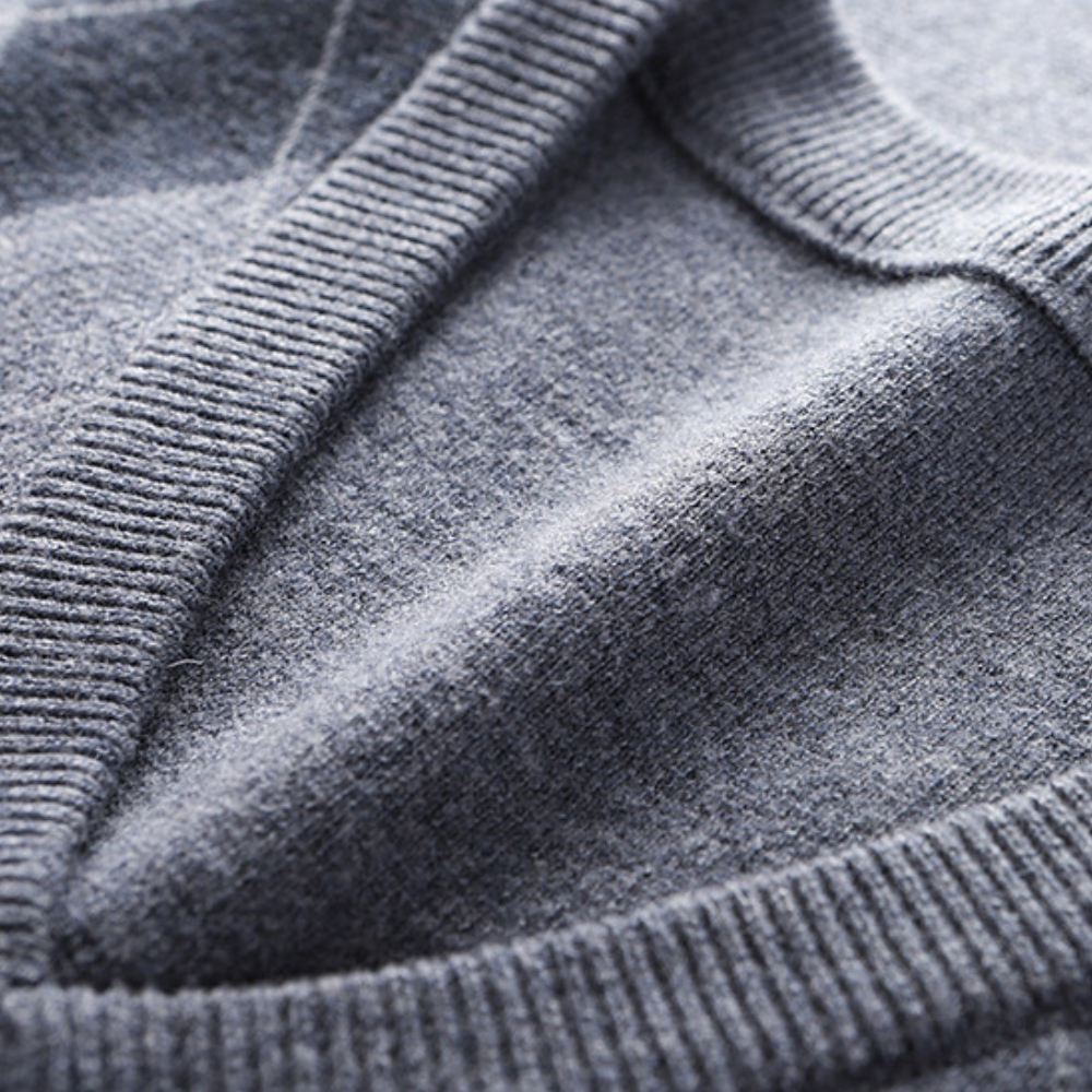 Grauer Kaschmirpullover, Nahaufnahme, weiches Material, hochwertige Strickmode, Detailansicht.
