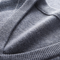 Grauer Kaschmirpullover, Nahaufnahme, weiches Material, hochwertige Strickmode, Detailansicht.