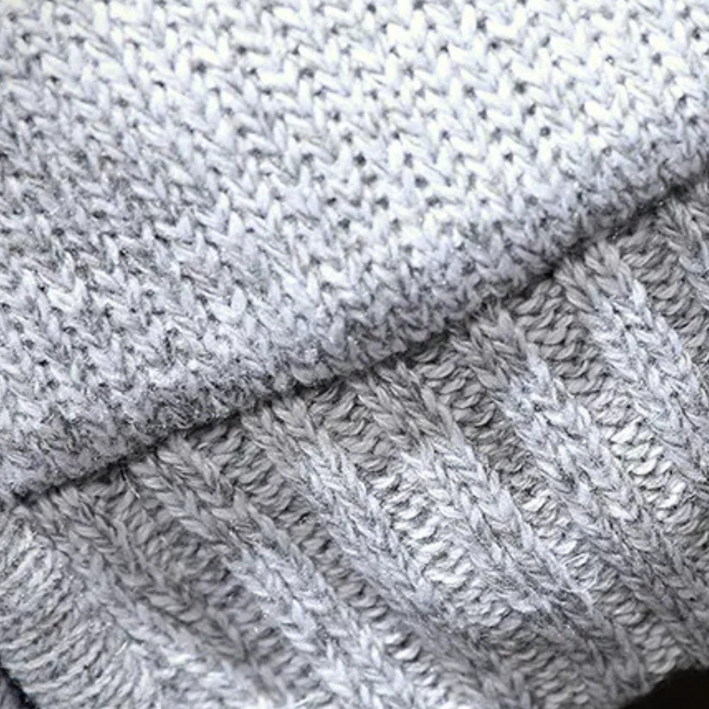 Grauer Strickpullover aus Wolle, Nahaufnahme, weiches Material, Wintermode, Texturdetails.