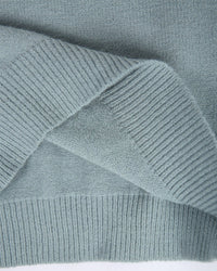 Grauer Strickpullover aus Wolle, Nahaufnahme, weiches Material, modisches Design, Herbstmode.