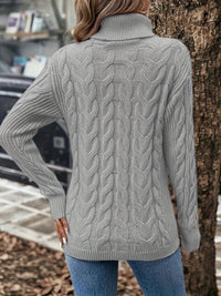 Frau in grauem Strickpullover mit Zopfmuster und Rollkragen, Herbstmode, Rückansicht.