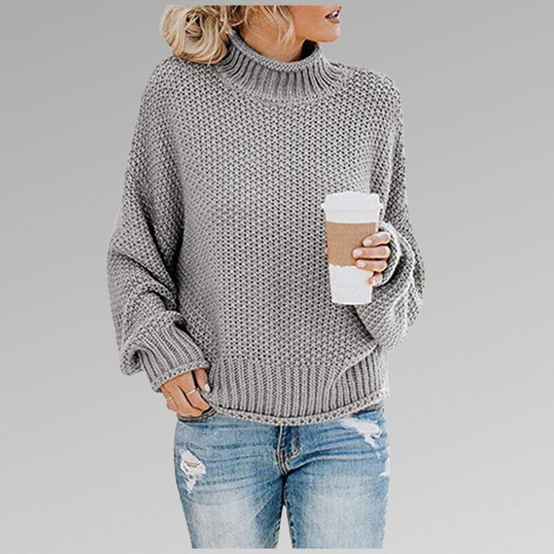 Frau in grauem Strickpullover mit Kaffeebecher, lässige Mode, Herbstoutfit, blaue Jeans.
