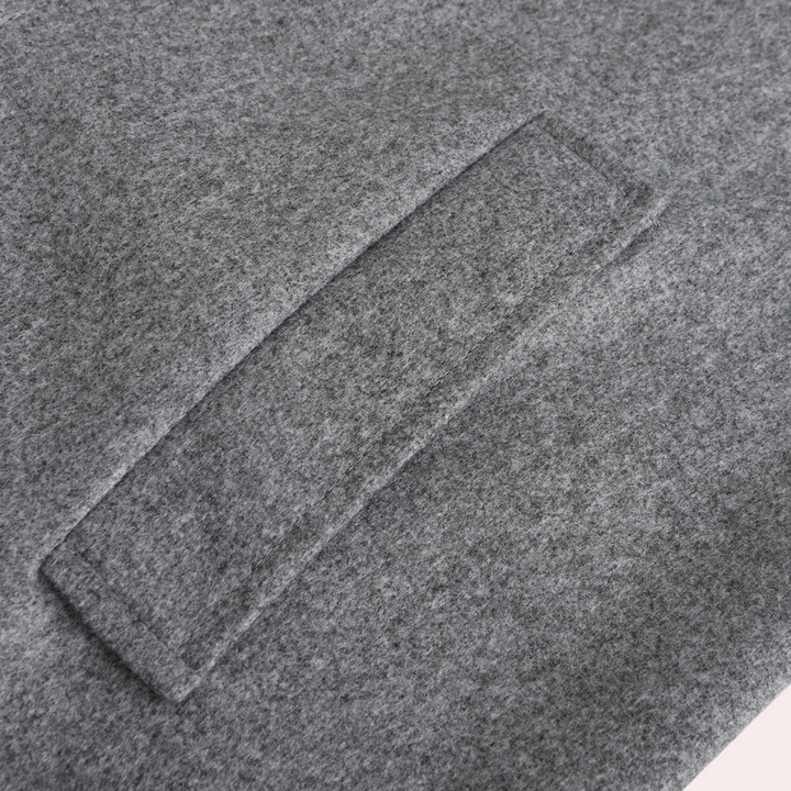 Grauer Wollstoff mit rechteckiger Naht, Detailansicht, hochwertige Textur, Mode, Bekleidung.