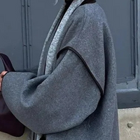 Grauer Wollmantel mit weitem Schnitt, elegantes Design, Damenmode, Herbst-Winter-Kollektion.