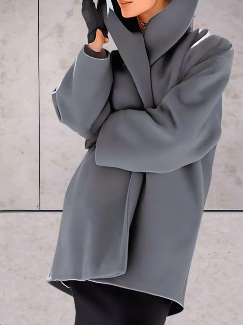 Frau in grauem Wollmantel mit Kapuze, elegantes Winteroutfit, modische Damenbekleidung.