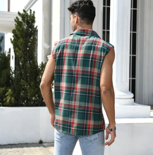 Mann in ärmellosem karierten Hemd, grün-rot, vor weißem Gebäude, lässige Mode.