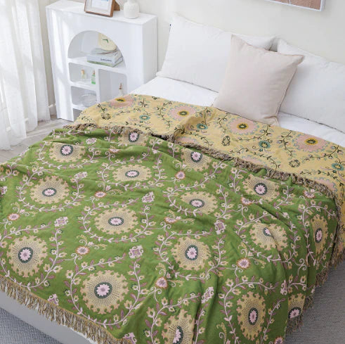 Grüne und gelbe bestickte Tagesdecke auf Bett, florales Muster, Schlafzimmerdekoration.