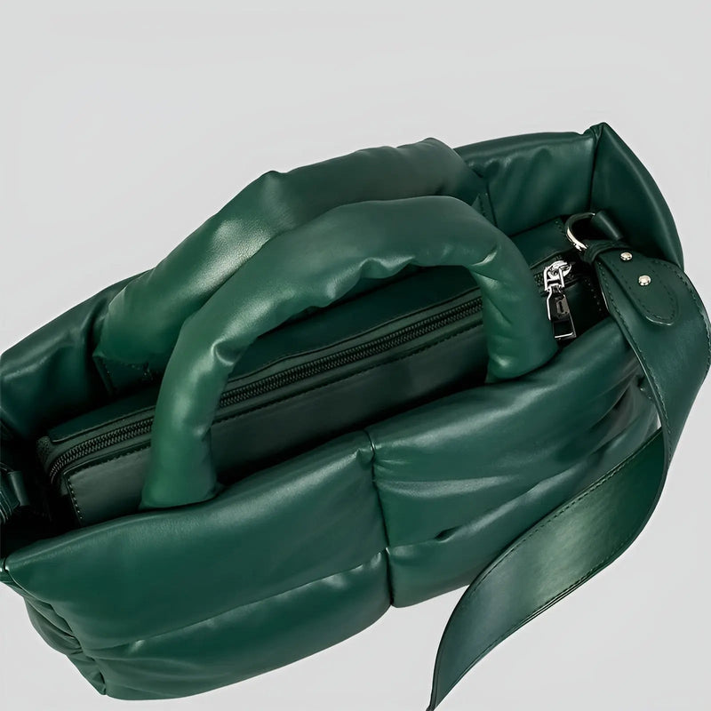 Grüne gesteppte Handtasche aus Leder mit Reißverschluss und verstellbarem Schulterriemen.