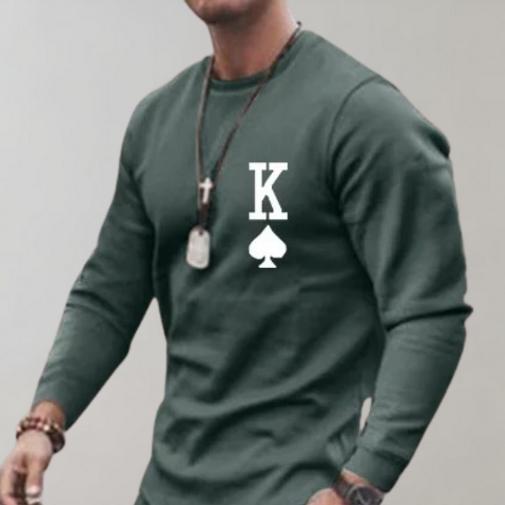 Mann in grünem Sweatshirt mit Karo-Symbol und K, lässige Mode, Herrenbekleidung.