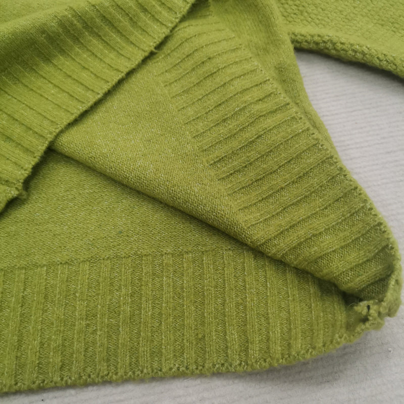 Grüner Strickpullover aus Baumwolle, Nahaufnahme, weiche Textur, modisches Design.