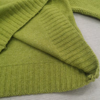 Grüner Strickpullover aus Baumwolle, Nahaufnahme, weiche Textur, modisches Design.