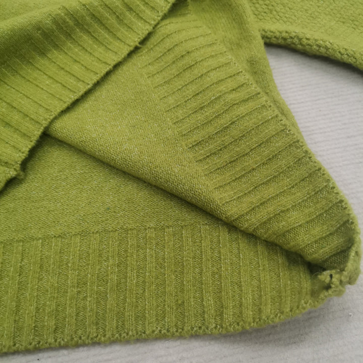 Grüner Strickpullover aus Baumwolle, Nahaufnahme, weiche Textur, modisches Design.