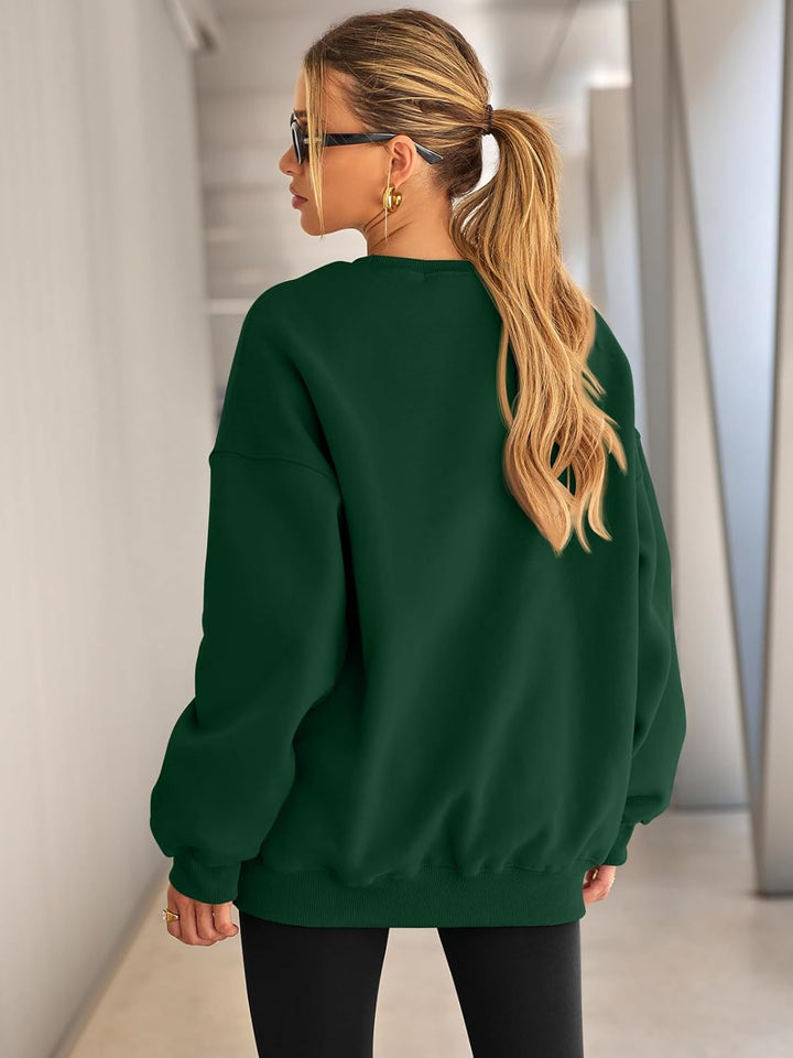 Frau in grünem Oversize-Pullover, blonde Haare, Sonnenbrille, modisch, urbaner Stil.