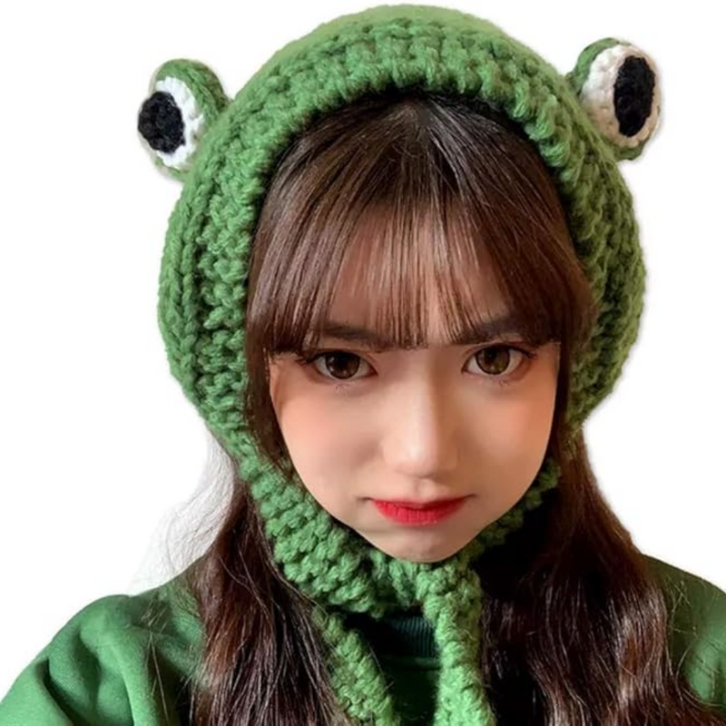 Frau mit grünem Frosch-Strickmütze, handgemacht, modisch, warm, Winteraccessoire.