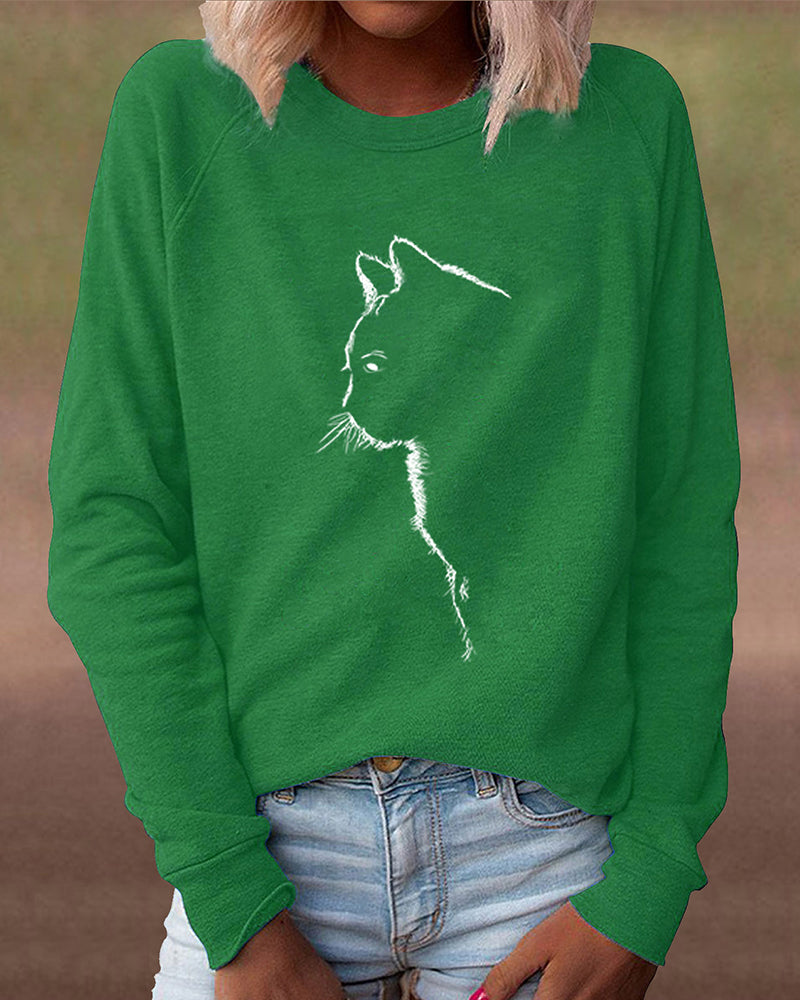 Frau trägt grünes Sweatshirt mit Katzenmotiv, lässige Mode, Damenbekleidung, Baumwolle.