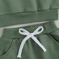 Grüner Baby-Sweatanzug aus Baumwolle mit weißer Kordel, bequem und modisch.