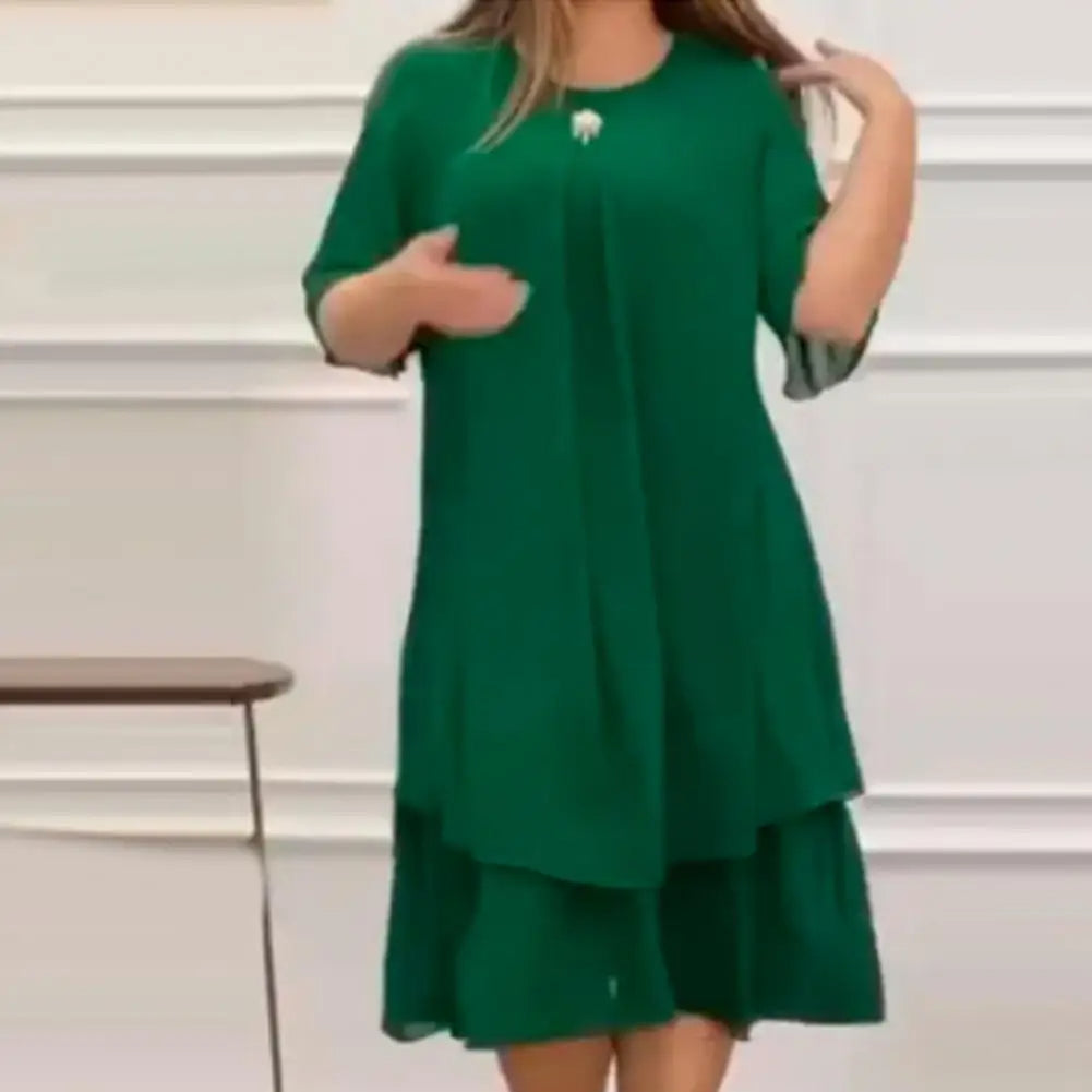 Frau in grünem Kleid, knielang, mit kurzen Ärmeln, elegantes Design, Innenraum.