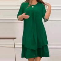 Frau in grünem Kleid, knielang, mit kurzen Ärmeln, elegantes Design, Innenraum.