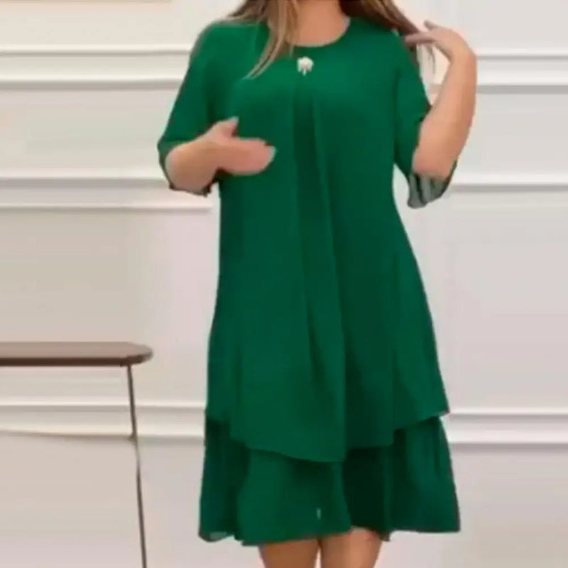 Frau in grünem Kleid, knielang, mit kurzen Ärmeln, elegantes Design, Innenraum.