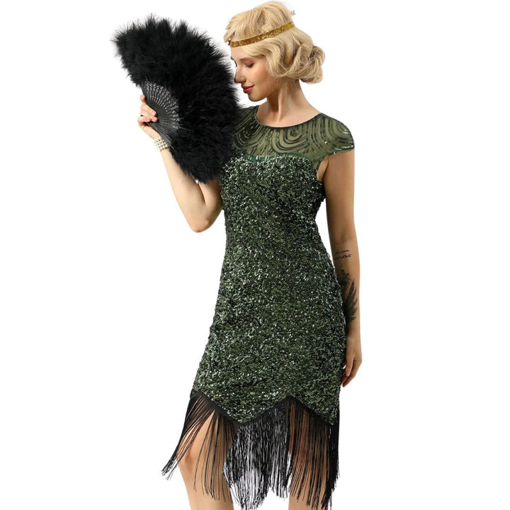 Frau im grünen Paillettenkleid mit Fransen, hält schwarzen Federfächer, Vintage-Stil.