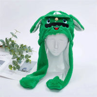 Grüne Plüschmütze mit Hasenohren und Gesichtsmotiv auf weißem Schaufensterkopf.