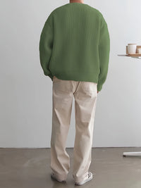 Mann in grünem Strickpullover und beigen Hosen, Rückansicht, lässige Mode, minimalistisch.