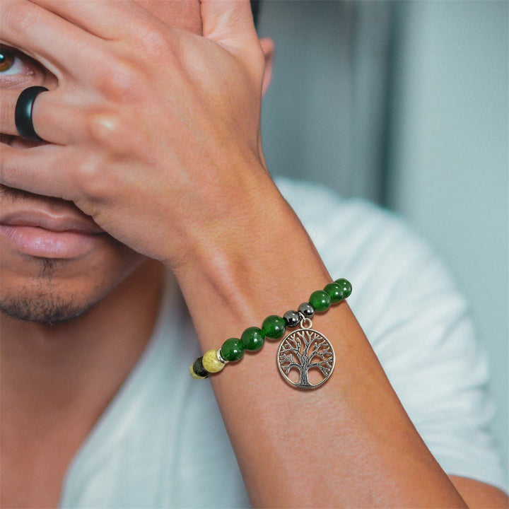 Mann mit grünem Armband und Lebensbaum-Anhänger, modisches Accessoire, Nahaufnahme.