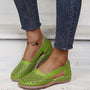 Grüne Damen-Loafers aus Leder mit Cut-Out-Design, getragen mit Jeans.