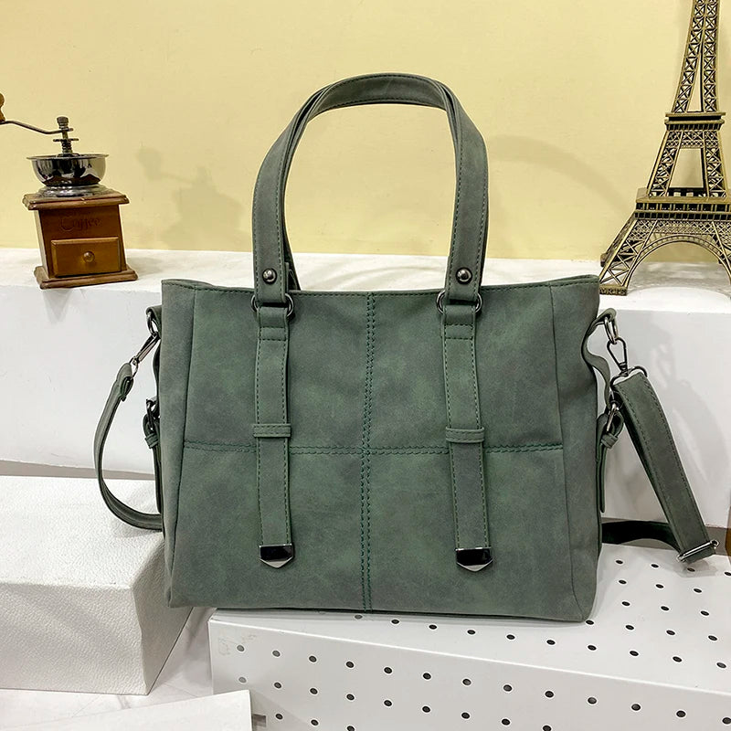 Grüne Damenhandtasche aus Leder mit Schulterriemen, elegant, modisch, vor Eiffelturm-Dekor.