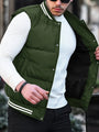 Mann in grüner Steppweste und weißem Pullover, modisch, Outdoor-Bekleidung, Herbstmode.