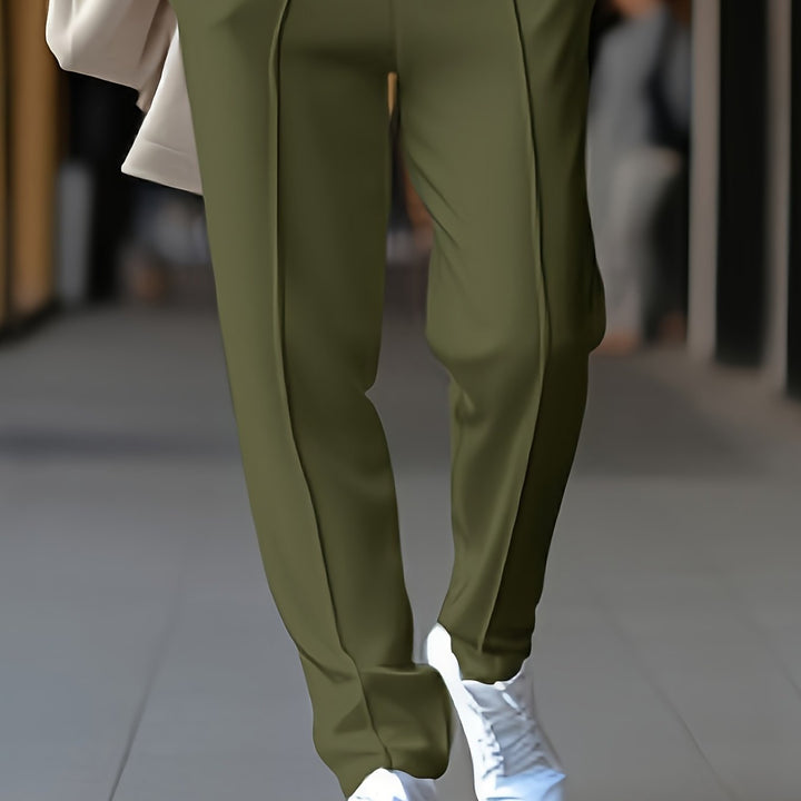 Grüne Damenhose, elegant, aus Baumwolle, ideal für Büro und Freizeit, kombiniert mit weißen Sneakern.