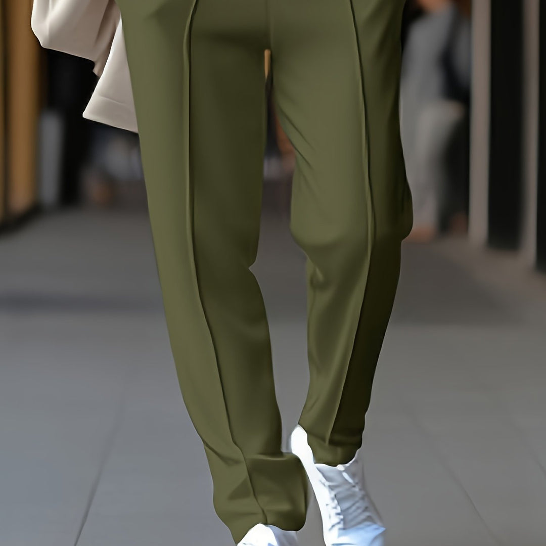 Grüne Damenhose, elegant, aus Baumwolle, ideal für Büro und Freizeit, kombiniert mit weißen Sneakern.