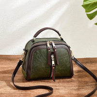 Grüne Lederhandtasche mit Reißverschlüssen, verstellbarem Riemen, modisch, elegant, Damenaccessoire.