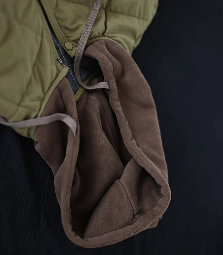 Grüne gesteppte Jacke mit braunem Fleecefutter, Reißverschluss, Kapuze, Outdoor-Bekleidung.