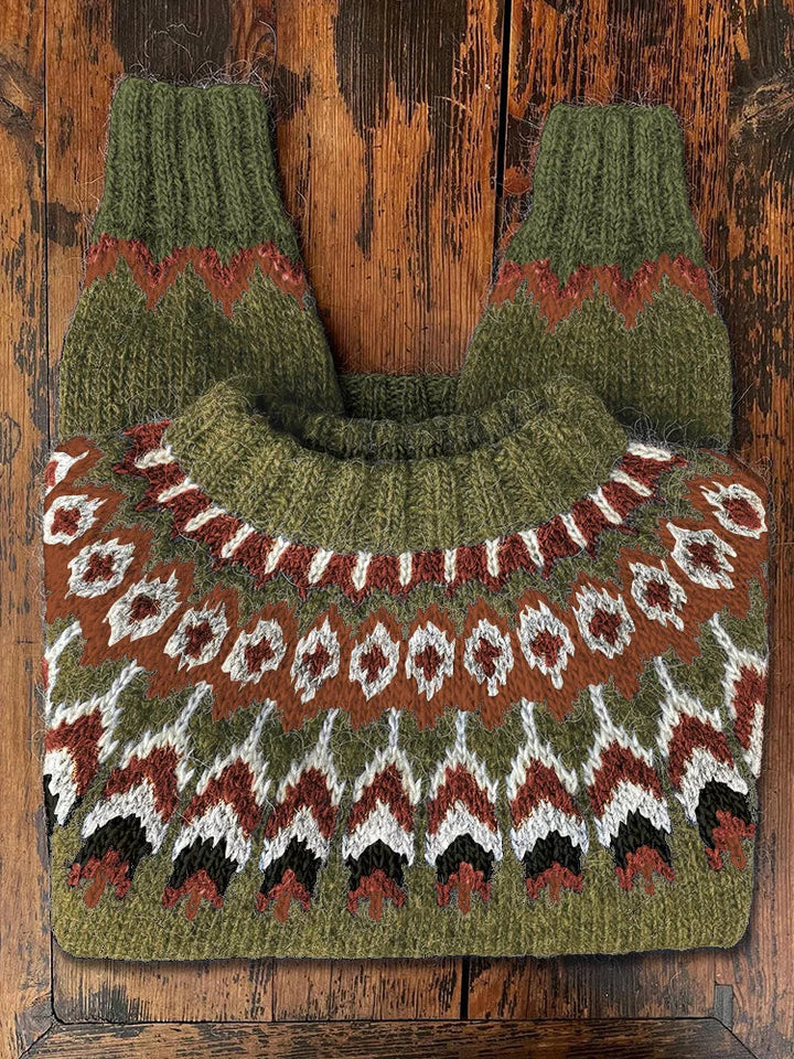 Grüner Norwegerpullover aus Wolle mit traditionellem Muster auf Holztisch.