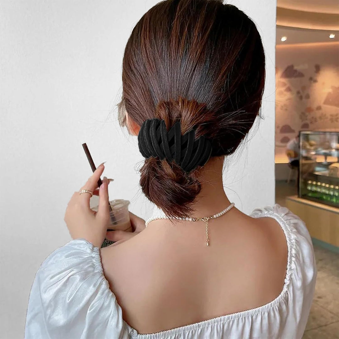 Frau mit schwarzem Haarklammer, eleganter Dutt, weißes Kleid, Café-Hintergrund.