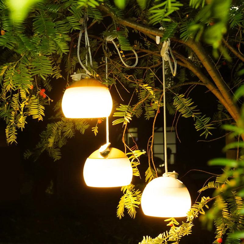 Drei hängende LED-Solarleuchten im Garten, warmweißes Licht, energiesparend, wetterfest.